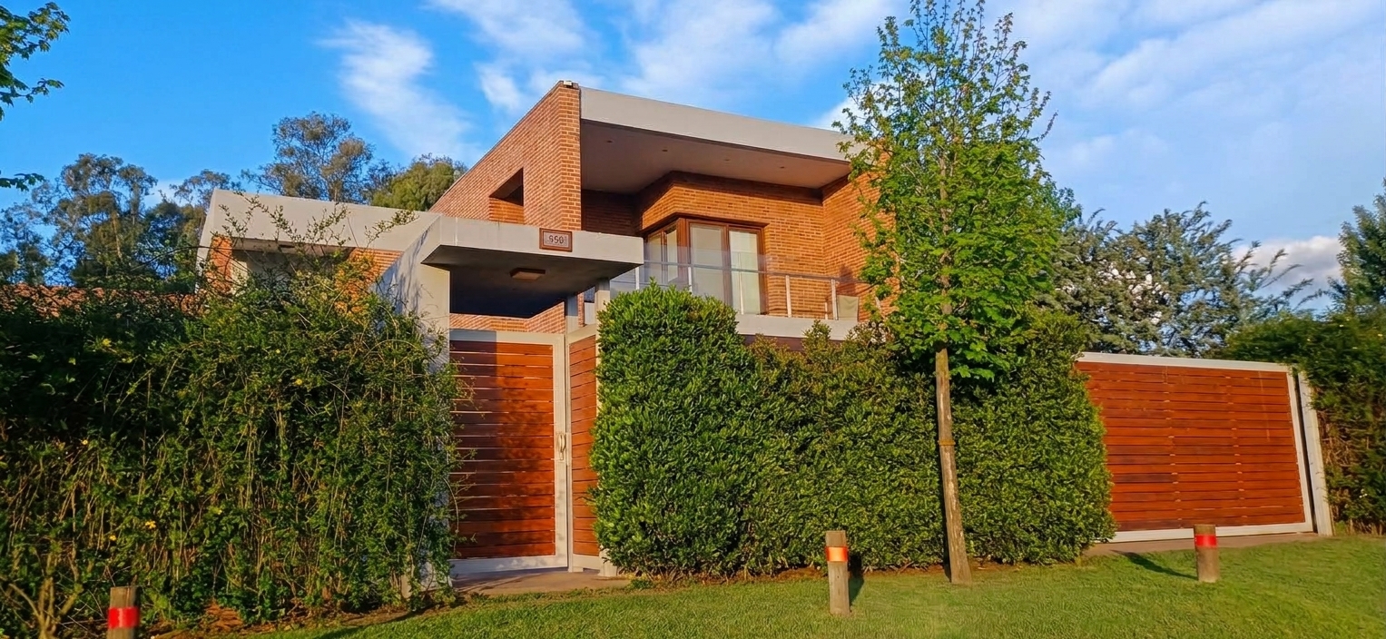 Vivienda de dos plantas en ladrillo visto con portones de madera