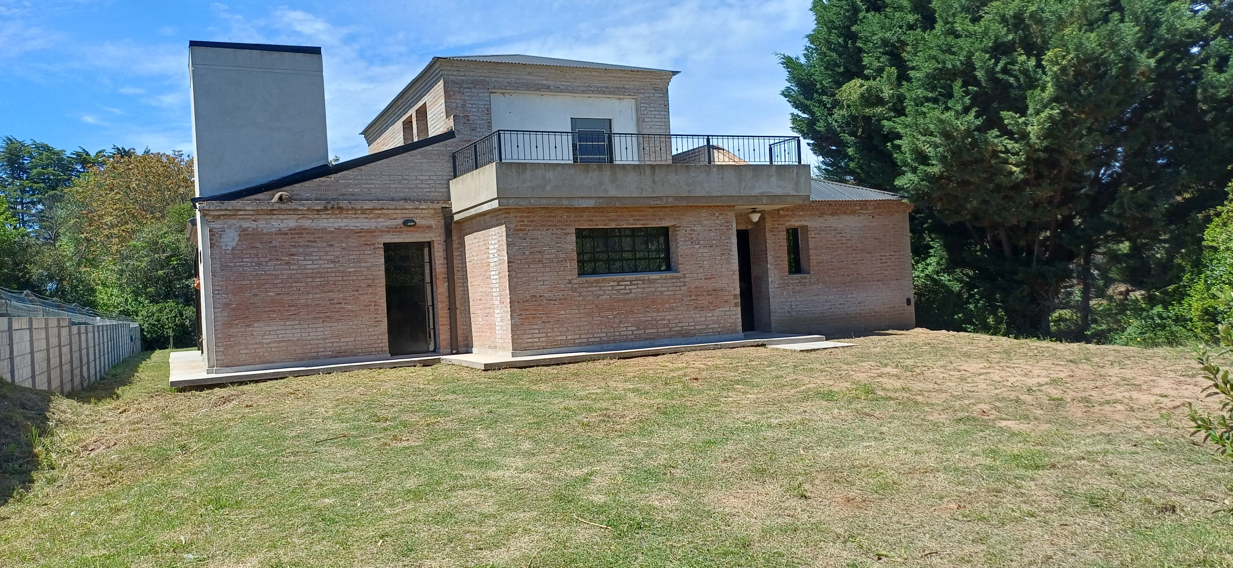 Casa contemporánea gris con palmeras y acceso central